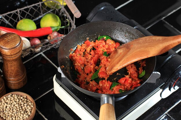 Kochprozess saute sambal oder sambel oder spicy sauce mit limettenblatt auf einer pfanne in der küche