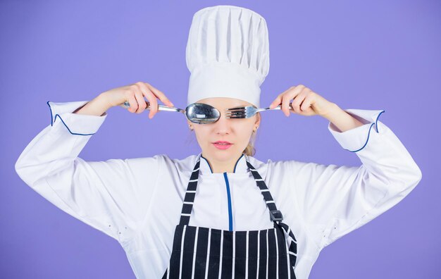 Kochschulkonzept. Frau professioneller Koch hält Utensilienlöffelgabel, die Spaß hat. Essenszeit. Appetit und Geschmack. Traditionelle Kulinarik. Professioneller Koch der Kochschule. Akademie der Kochkunst.