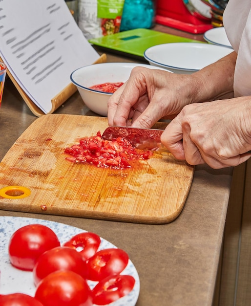 Köche schneiden frische Tomaten auf einem Holzschnittbrett in der Küche