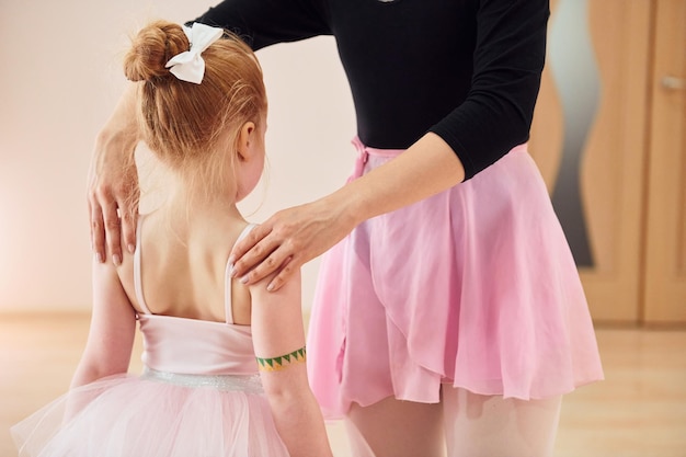 Körperhaltung fixieren Kleine Ballerinas bereiten sich auf den Auftritt vor, indem sie Tanzbewegungen üben