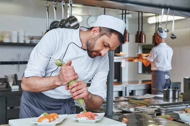 Köstlich serviertes frisches Sushi-Meister bereitet Sushi zum Servieren in der modernen Großküche zu