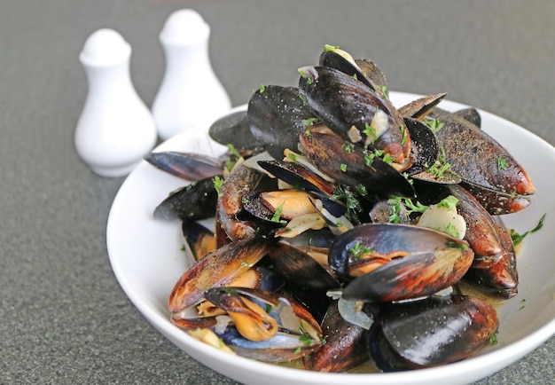 Köstliche belgische gedämpfte Muscheln in Weißwein und Knoblauch oder Moules Mariniere