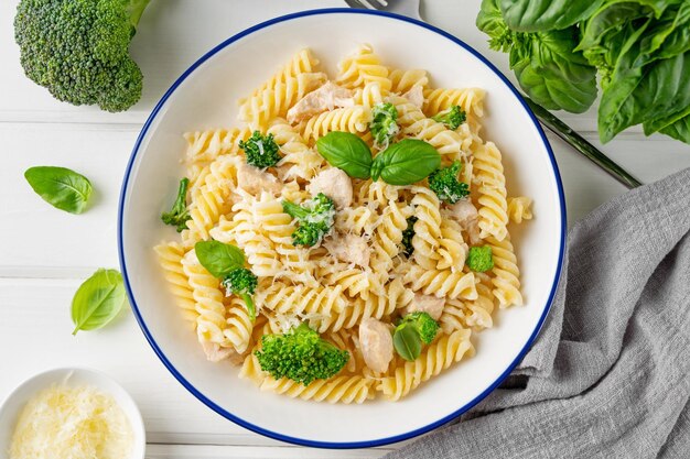 Foto köstliche brokkoli- und hühnerfusilli-pasta mit parmesan-käse und frischem basilikum in einer schüssel