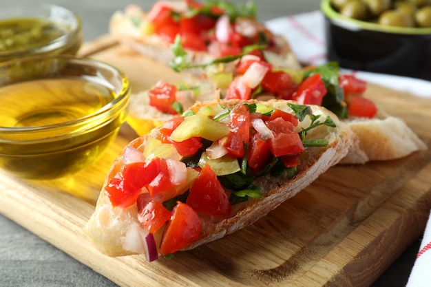 Köstliche Bruschetta-Snacks auf grauem strukturiertem Tisch