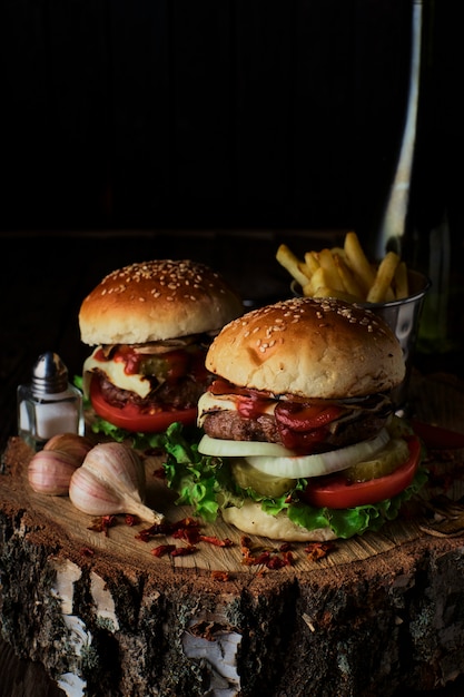 Foto köstliche burger in einer rustikalen art auf dunklem hölzernem hintergrund.