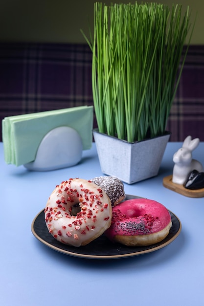 Köstliche Donuts auf einem Teller auf blauem Hintergrund