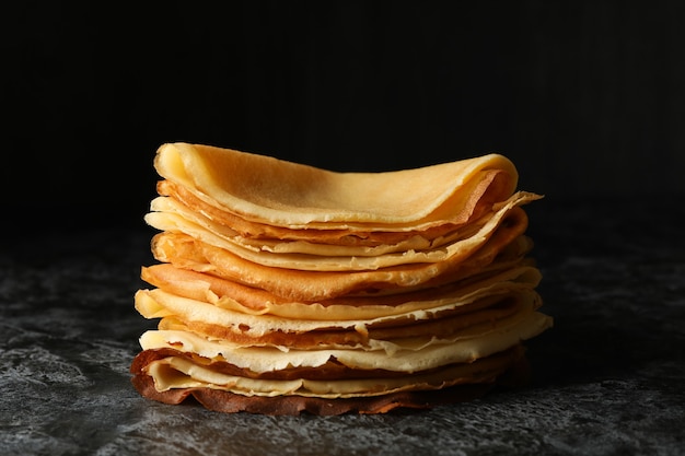 Köstliche dünne Pfannkuchen auf schwarzem rauchigem Hintergrund