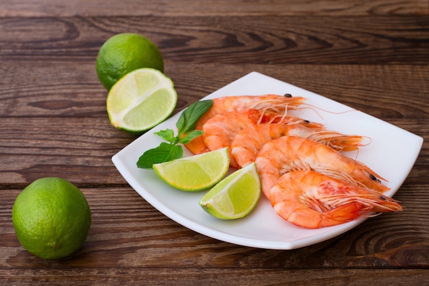 Köstliche frische Garnelen mit Limette auf Holztisch