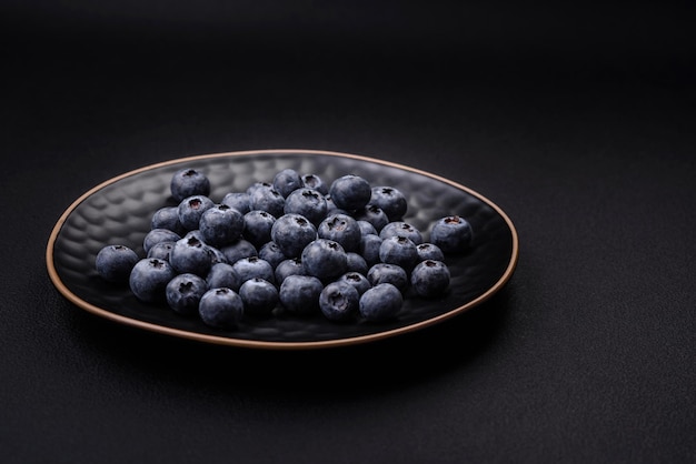 Köstliche frische Heidelbeeren auf einem strukturierten schwarzen Betonhintergrund