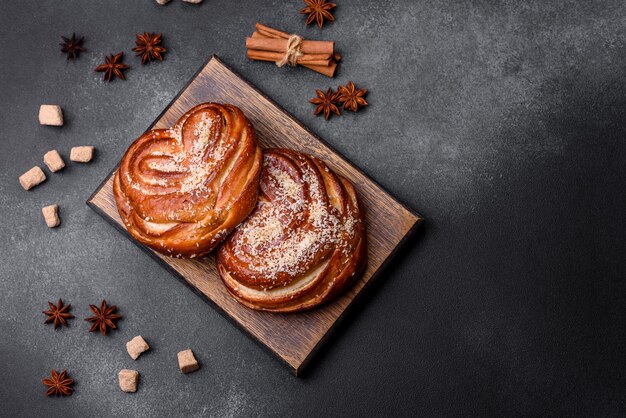 Köstliche, frische, knusprige Zimtbrötchen, bestreut mit Kokoskrümeln auf einem Holzschneidebrett