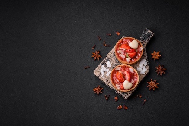 Köstliche frische süße Törtchen mit Erdbeeren und Kokosflocken