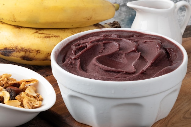 Foto köstliche gefrorene acai in einer schüssel serviert mit müsli und banane. selektiver fokus