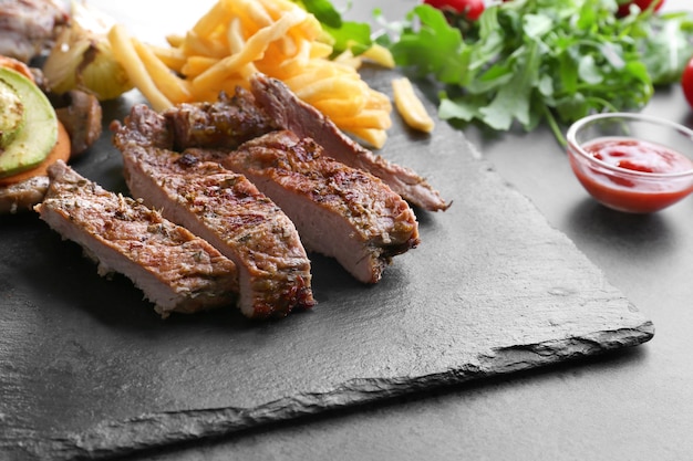 Köstliche gegrillte Steakfrites auf Schieferplatte