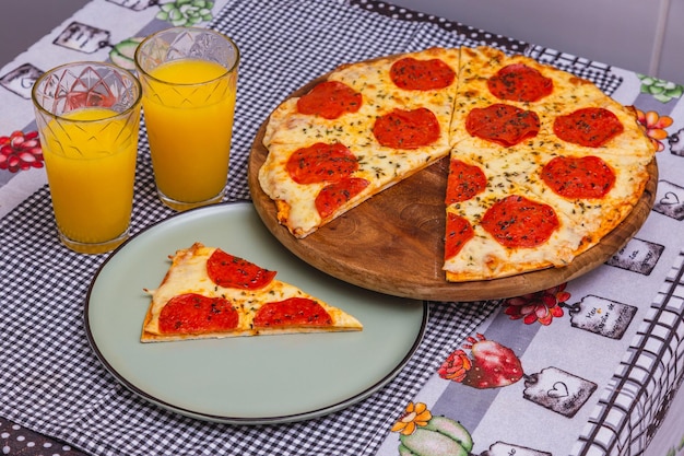 Köstliche geschnittene Peperoni-Pizza gebackene Pizza Hauspizza mit Orangensaft