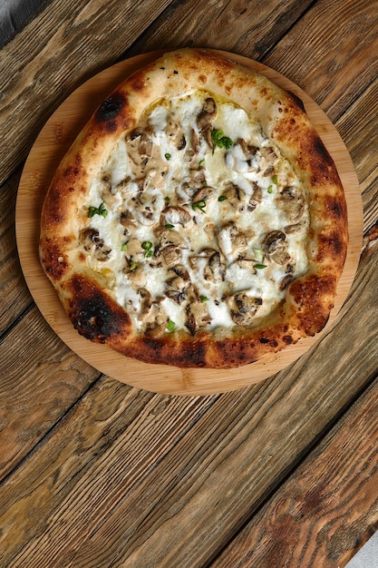 Köstliche hausgemachte Pizza mit Mozzarella-Pilzen, Rindfleisch und Hähnchen Holzhintergrund, selektiver Fokus