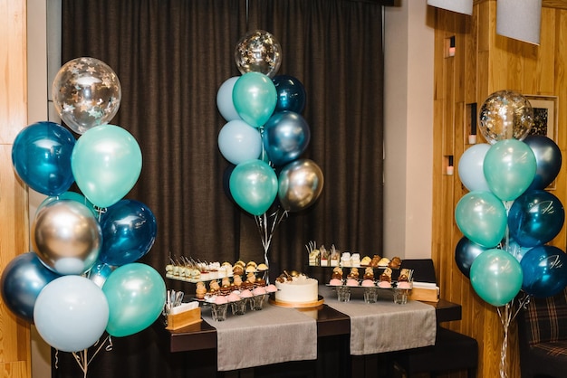 Köstliche Hochzeitsfeier Geburtstagstorte auf einem Hintergrund Luftballons Partydekor Platz kopieren Feierkonzept Trendy Cake Candy Bar Tisch mit Süßigkeiten Dessert