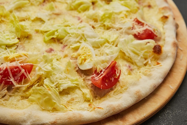 Köstliche italienische Pizza Caesar auf dunklem Tisch