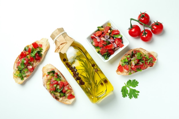 Köstliche italienische Snacks Bruschetta und Zutaten auf weißem Hintergrund