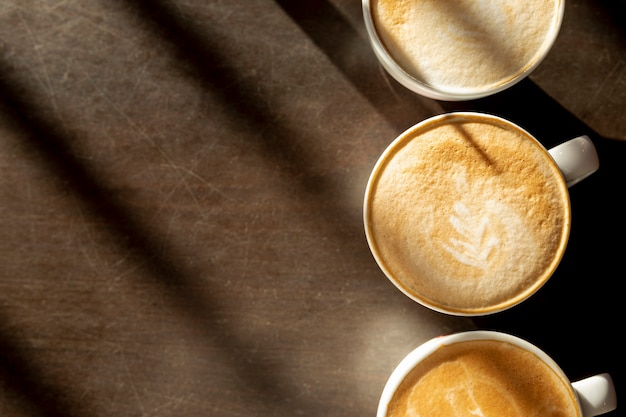 Köstliche Kaffeetassen der Draufsicht mit Milch auf dem Tisch