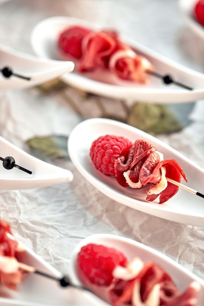 Köstliche Kanapees Hamon mit Himbeeren Konzept des Catering-Menüs im Restaurant