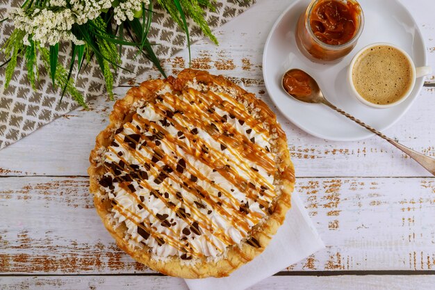 Köstliche Karamell-Schokoladen-Cremetorte mit einer Tasse Kaffee