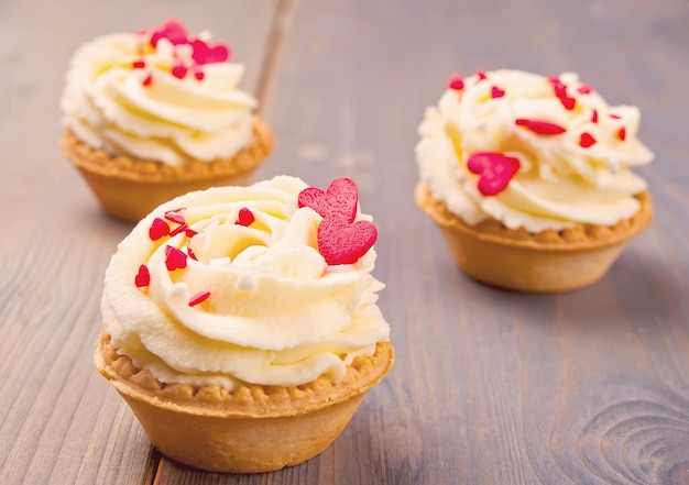 Köstliche kleine Kuchen für Valentine Day auf hölzernem Hintergrund