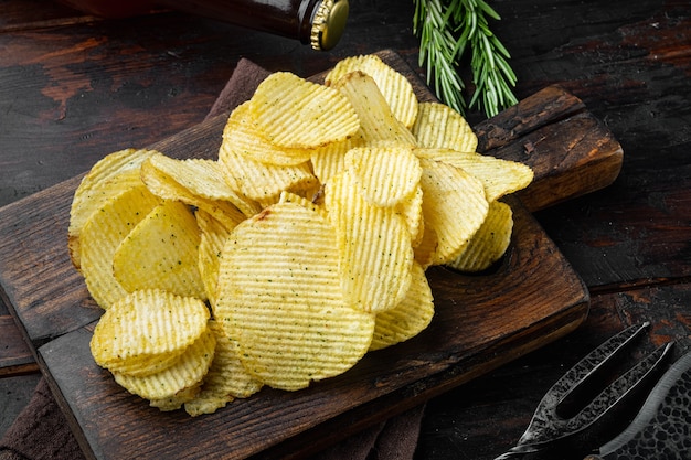 Köstliche knusprige Kartoffelchips auf altem dunklem Holztisch