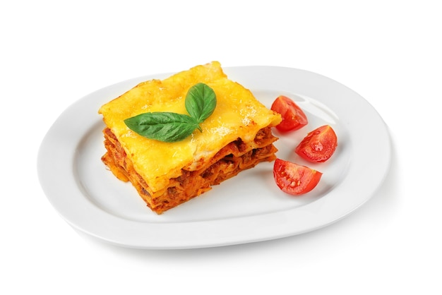 Köstliche Lasagne und Tomaten auf weißem Hintergrund