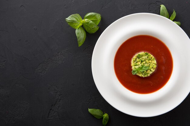 Köstliche leckere kalte Tomatensuppe Gazpacho mit Avocado hautnah. Portion traditioneller spanischer roter Gemüsebrühe, Restaurant, Kopienraum, Draufsicht