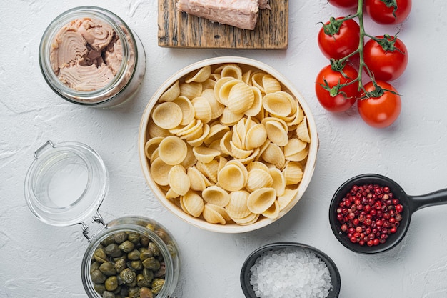 Köstliche Lumaconi-Pasta-Mahlzeit mit Thunfisch und Baby-Kapern, auf weißem Hintergrund, Ansicht von oben