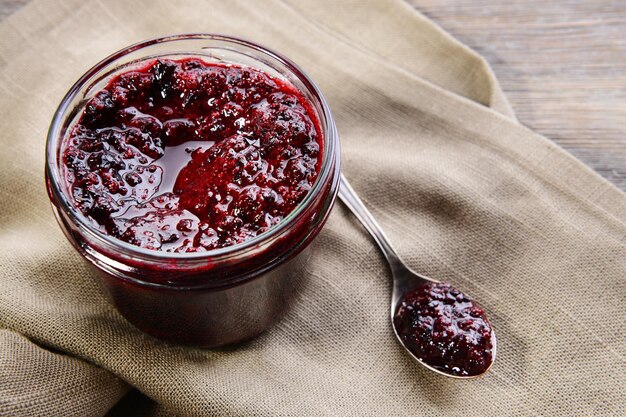 Foto köstliche marmelade aus schwarzen johannisbeeren auf dem tisch in der nähe