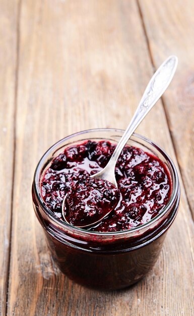 Köstliche Marmelade aus schwarzen Johannisbeeren auf dem Tisch in der Nähe