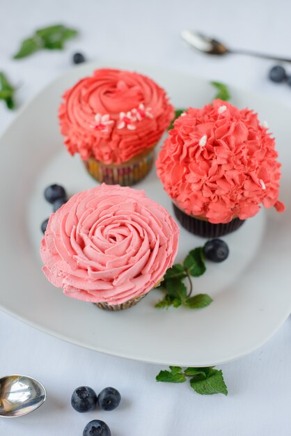 Köstliche mehrfarbige Cupcakes auf einem weißen Teller.