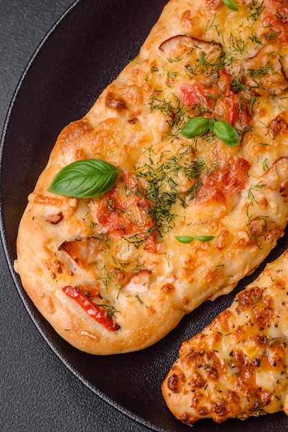 Köstliche ofenfrische Fladenbrotpizza mit Käse, Tomaten, Wurst, Salz und Gewürzen