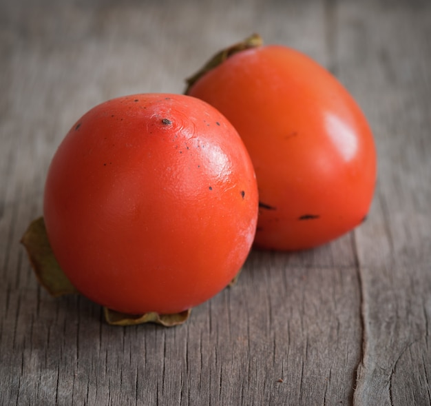 Köstliche orangefarbene Kakis auf Holztisch