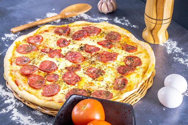 Foto köstliche peperoni-pizza mit eiern, weizen, knoblauch, tomaten und käse auf dunklem hintergrund