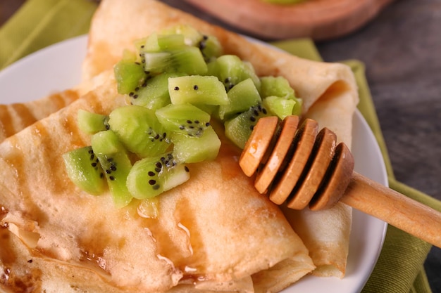 Köstliche Pfannkuchen mit Kiwi auf Plattennahaufnahme