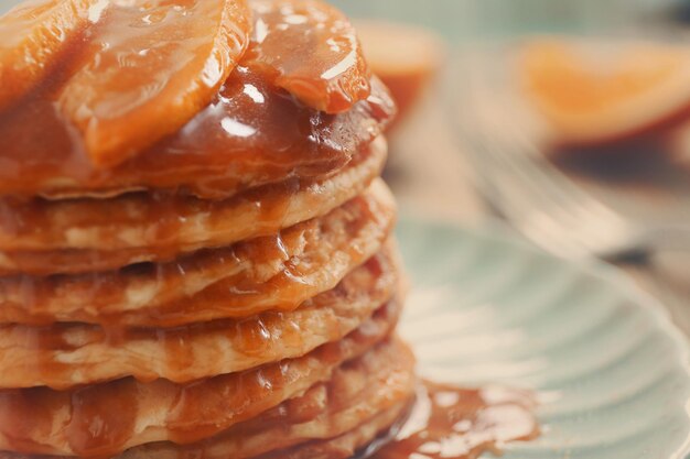 Foto köstliche pfannkuchen mit orangenscheiben und sirup in nahaufnahme