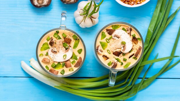 Köstliche Pilzcremesuppe mit Gewürzen auf einem Holztisch.