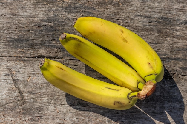 Köstliche reife gelbe Bananen auf rustikalem Holztisch. Ansicht von oben