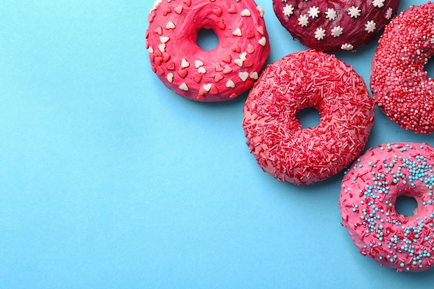 Köstliche rosa Donuts auf farbigem Hintergrund