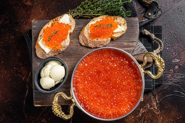 Köstliche Sandwiches mit Fisch Roter Kaviar auf Holzbrett Dunkler Hintergrund Ansicht von oben