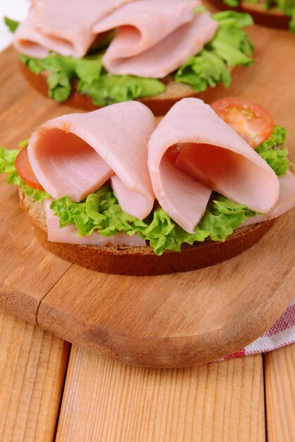 Köstliche Sandwiches mit Salat und Schinken auf dem Tisch