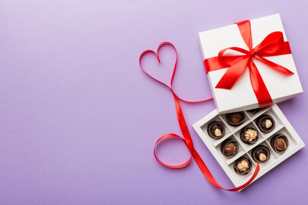 Köstliche Schokoladenpralinen in roter Schachtel zum Valentinstag Herzförmige Pralinenschachtel Draufsicht mit Kopierraum