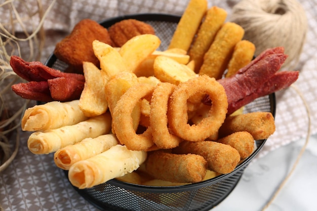 Köstliche Snackplatte Pommes Frites Zwiebelringe Frühlingsrollen oder Würstchen auf dem Tisch