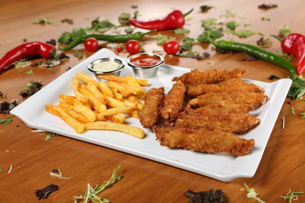 Köstliche Snackplatte Pommes Frites Zwiebelringe Frühlingsrollen oder Würstchen auf dem Tisch