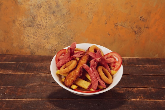 Köstliche Snackplatte Pommes Frites Zwiebelringe Frühlingsrollen oder Würstchen auf dem Tisch