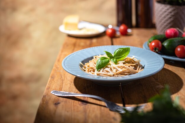Köstliche Spaghetti in einem blauen Teller. Hausgemachtes gesundes Slow Food. Familientraditionen