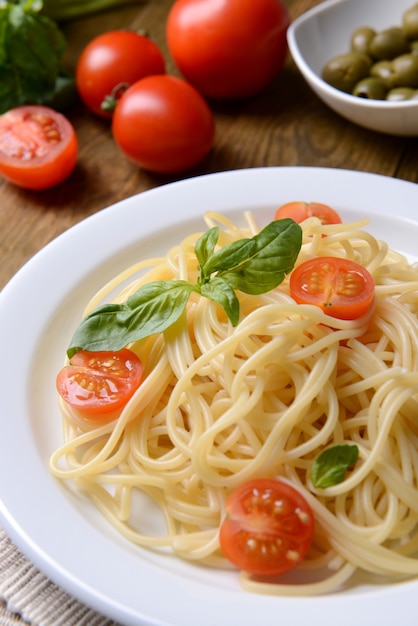 Köstliche Spaghetti mit Tomaten auf Teller auf Tischnahaufnahme