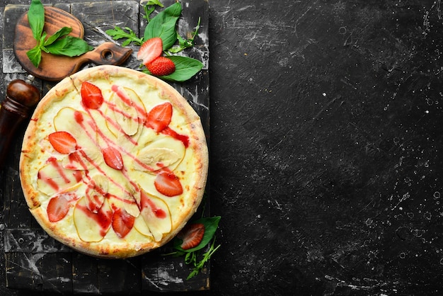 Köstliche süße Pizza mit Erdbeeren und Banane. Ansicht von oben. Nachtisch.